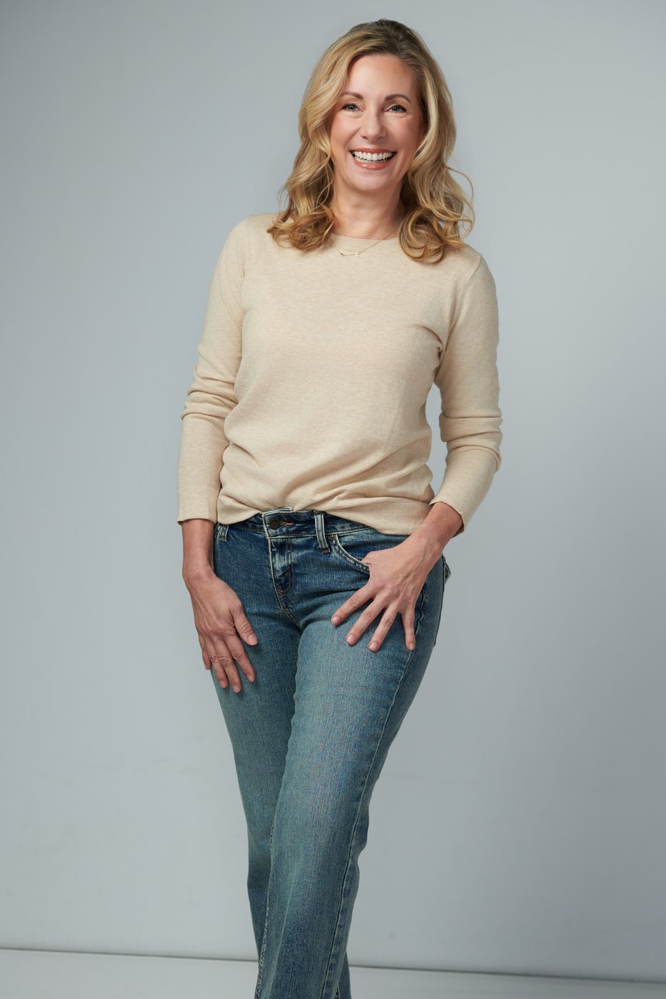 Dr. Stephanie Moore standing casually in a cream sweater and jeans