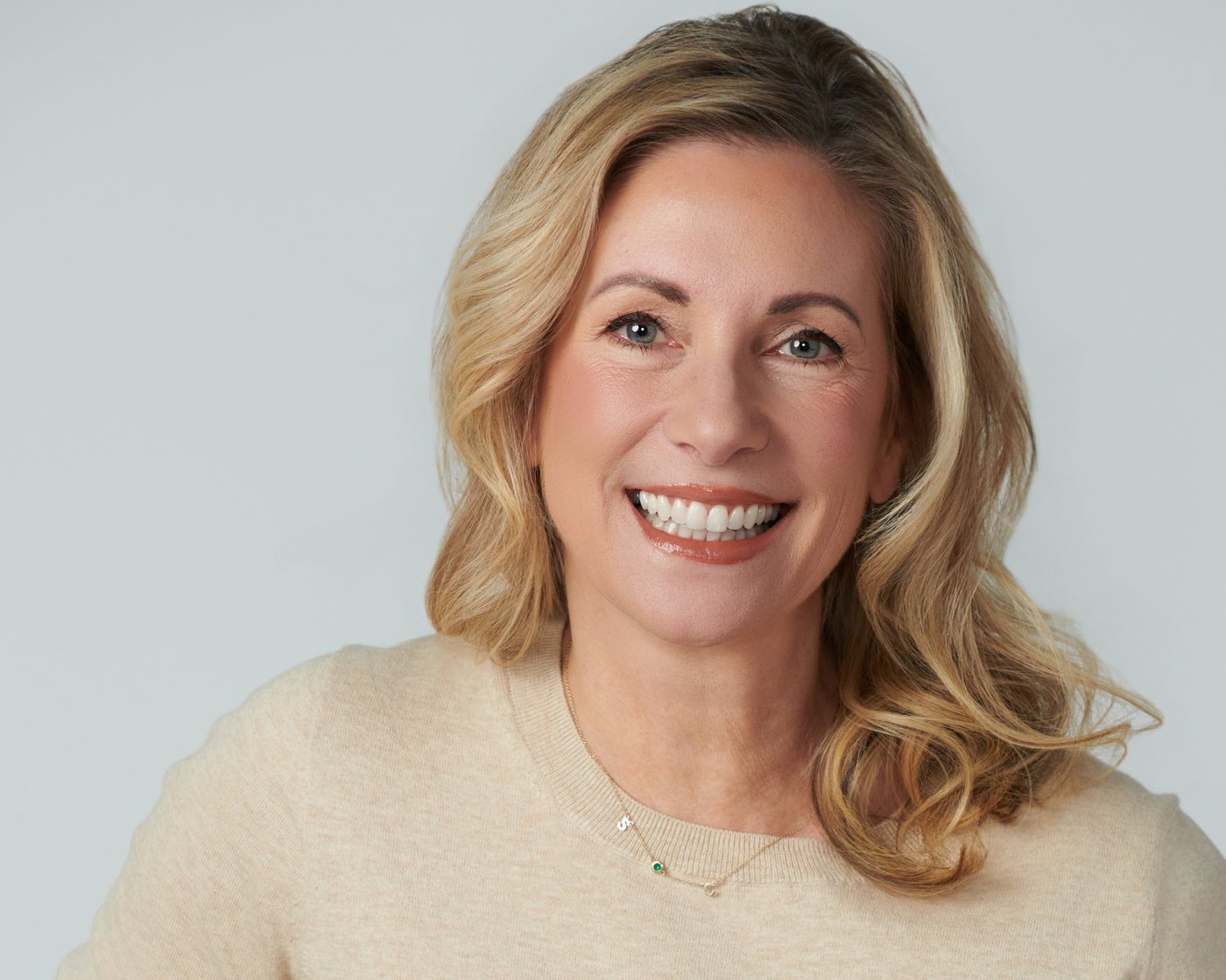 Portrait of Dr. Stephanie Moore smiling, wearing a cream sweater