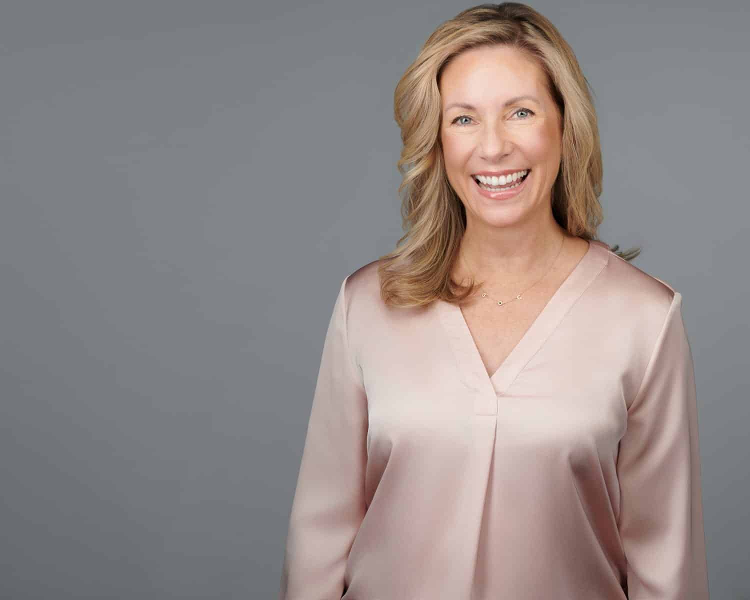 Dr. Stephanie Moore smiling, wearing a soft pink blouse