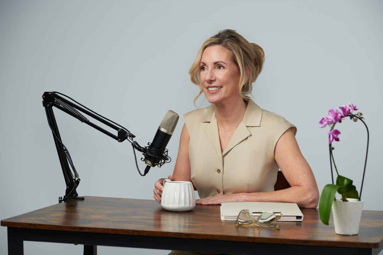 Dr. Stephanie Moore seated at a podcast desk with a studio microphone