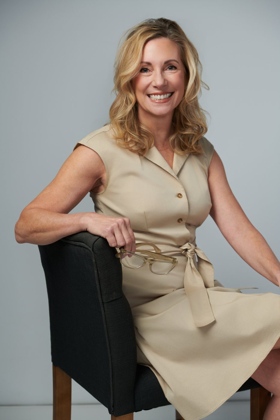 Dr. Stephanie Moore seated on a chair in a tan dress